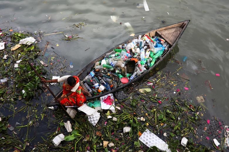 A woman collects plastic waste from the Buriganga river in Dhaka, Bangladesh. REUTERS/Mohammad Ponir Hossain  